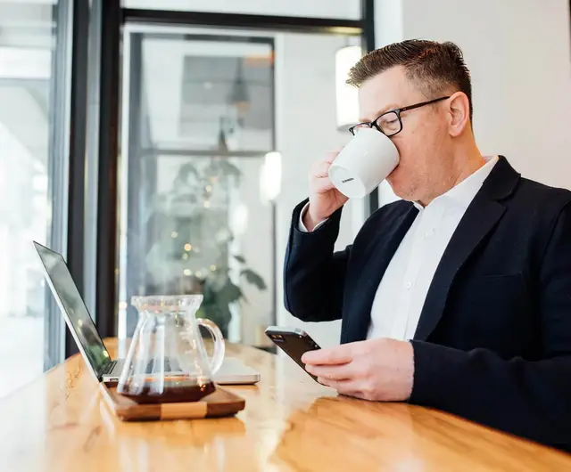 Business owner placing a current owner title search order from a coffee shop
